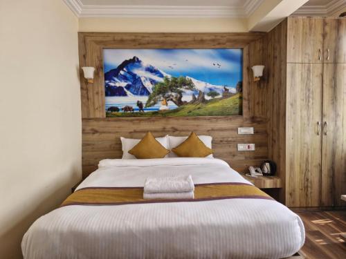 Un dormitorio con una cama grande con un cuadro en la pared. en Prem Durbar Hotel, en Changunarayan