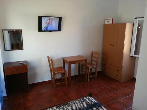 a room with a table and chairs and a cabinet at Vintage House-Vori-Rent Rooms in Vóroi