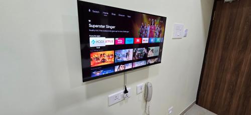 a flat screen tv hanging on a wall at Hotel NJ RESIDENCY NEAR DLF IT PARK, RMZ SOFTWARE PARK, L&T ECC, CHENNAI TRADE CENTRE & MIOT in Chennai