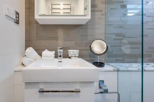 a bathroom with a white sink and a mirror at Explore Sydney from Stylish North Shore Apartment in Sydney