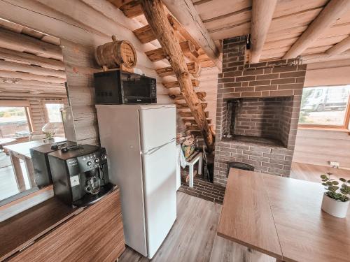a kitchen with a refrigerator and a brick fireplace at Poilsis netoli Druskininkų in Druskininkai