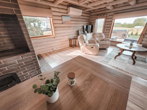 a living room with a fireplace in a log cabin at Poilsis netoli Druskininkų in Druskininkai