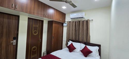 a bedroom with a bed with red and white pillows at Hotel NJ RESIDENCY NEAR DLF IT PARK, RMZ SOFTWARE PARK, L&T ECC, CHENNAI TRADE CENTRE & MIOT in Chennai