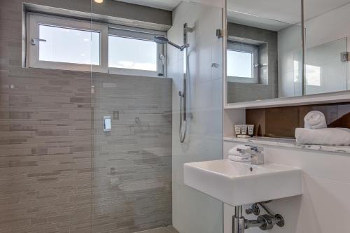 a white bathroom with a sink and a shower at Professional living minutes from the city in Sydney