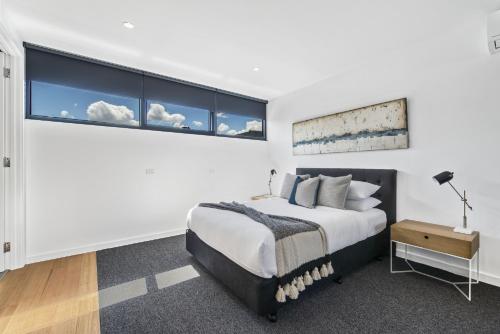a bedroom with a bed and a large window at Stylish Studio with Great Amenities near Beachside in Melbourne