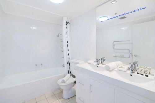 La salle de bains blanche est pourvue d'une baignoire, de toilettes et d'un lavabo. dans l'établissement Perfect Pyrmont penthouse with Sydney Tower View, à Sydney