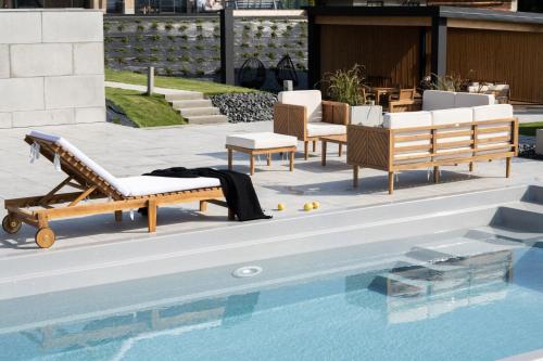a pool with lounge chairs and a table at Chaletovo Mountain Residences in Zakopane