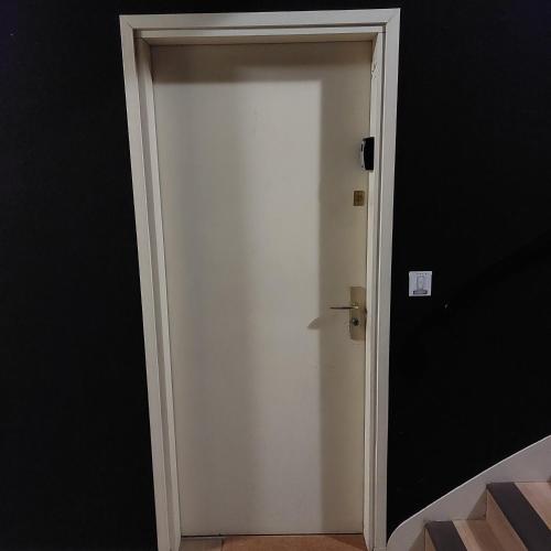 a white door in a room with a black wall at La Pause Valognaise "Parking privé" in Valognes