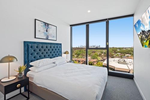 a bedroom with a large bed and large windows at Skyview1-Bed, Infinity Pool, Cinema, Gym & BBQ in Melbourne