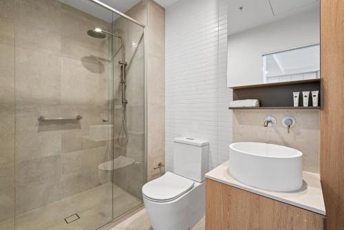 a bathroom with a toilet and a glass shower at Skyview1-Bed, Infinity Pool, Cinema, Gym & BBQ in Melbourne