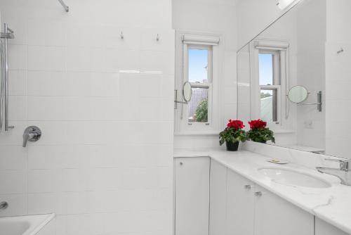 a white bathroom with two sinks and a mirror at Family Terrace Home Close to Oxford Street and CBD in Sydney