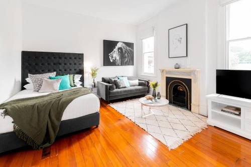 a bedroom with a bed and a living room with a fireplace at Cosy nook in inner-city Victorian mansion in Sydney