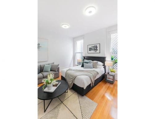 a bedroom with a bed and a couch at Renovated studio in bohemian area close to city in Sydney