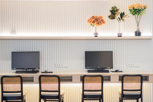 a waiting room with four chairs and two monitors at Blue Hippo & Red Crocodile Hotel in Bangna