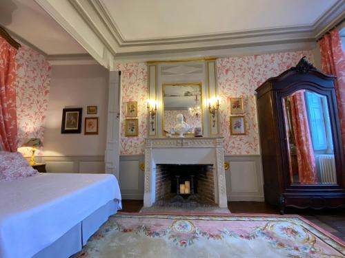 - une chambre avec une cheminée, un lit et un miroir dans l'établissement Chateau de Colombe, à Saint-Baudel