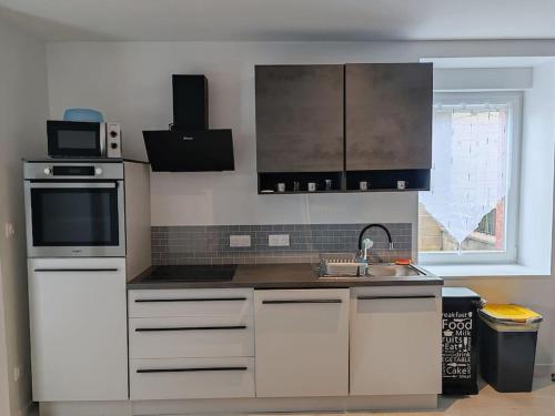 une cuisine avec un évier et un micro-ondes dans l'établissement Maison de campagne, à Fenneviller