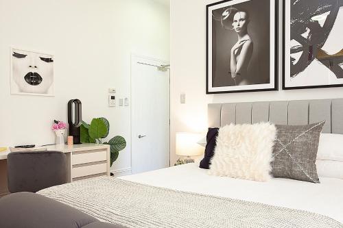 a white bedroom with a bed and a desk at Charming Studio With Balcony in Inner-City Glebe in Sydney