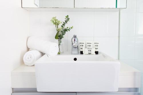 a white sink with a vase on it in a bathroom at Charming Studio With Balcony in Inner-City Glebe in Sydney