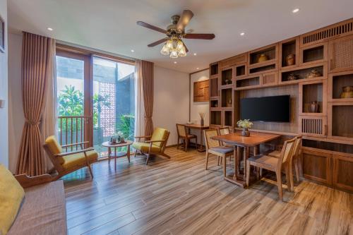a living room with a dining table and a television at Bonny Boutique Hotel Da Nang in Da Nang