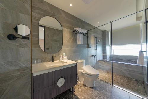 石門區的住宿－半島海悅渡假會館，一间带水槽、卫生间和镜子的浴室