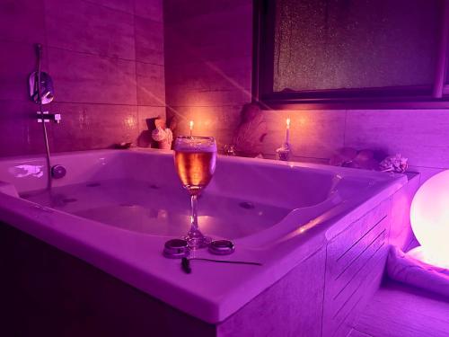 eine Badewanne mit einem Glas Wein darin in der Unterkunft palazzo della dolce vita in Santiago