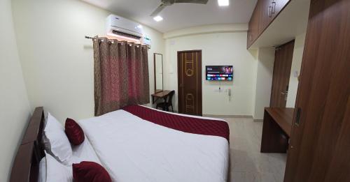 a bedroom with a bed and a television in it at Hotel NJ RESIDENCY NEAR DLF IT PARK, RMZ SOFTWARE PARK, L&T ECC, CHENNAI TRADE CENTRE & MIOT in Chennai