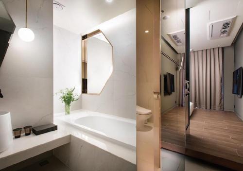 a bathroom with a tub and a sink and a mirror at Park Marine Hotel in Incheon