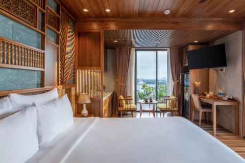 a bedroom with a large white bed and a desk at Bonny Boutique Hotel Da Nang in Da Nang