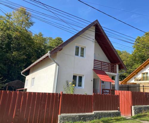 een wit huis met een rood hek bij Casa Micul Arin in Sovata