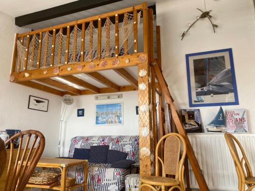 - un escalier en bois dans une chambre avec un canapé dans l'établissement Bel appartement les roches Brunes vue mer, au Cap d'Agde