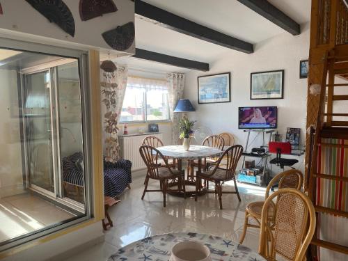 une salle à manger avec une table et des chaises dans l'établissement Bel appartement les roches Brunes vue mer, au Cap d'Agde