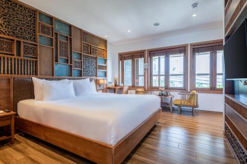 a bedroom with a large bed and a desk at Bonny Boutique Hotel Da Nang in Da Nang