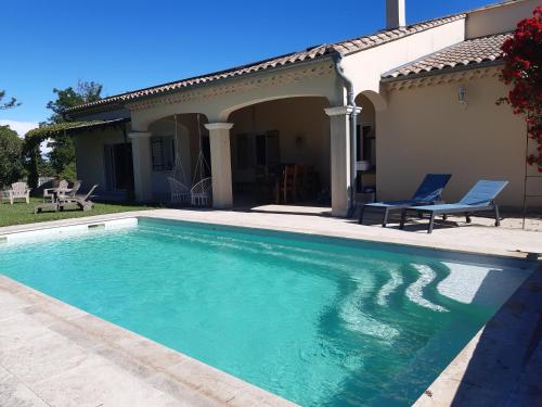 une piscine devant une maison dans l'établissement la villa de la fontaine, à Mondragon