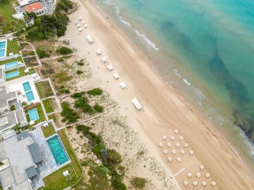 an aerial view of a beach with umbrellas at Mandola Rosa at Riviera Olympia, A Grecotel Resort to Live in Loutra Killinis
