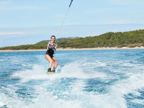 a person water skiing on a board in the water at Mandola Rosa at Riviera Olympia, A Grecotel Resort to Live in Loutra Killinis
