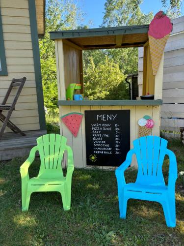 two chairs sitting in the grass next to a chalkboard at Nice child-friendly house 200m from beautiful beach,near Kullaberg in Farhult