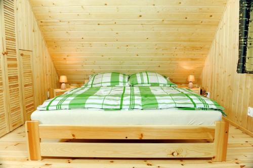 sypialnia z łóżkiem w drewnianym pokoju w obiekcie CAŁOROCZNE DOMKI NAD MORZEM I JEZIOREM w mieście Jezierzany