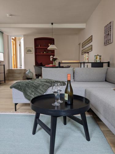 a living room with a bottle of wine and glasses on a table at Im Krämerladen in Neustadt an der Weinstraße