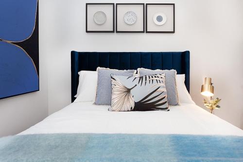a bedroom with a blue and white bed with pillows at Bright and Beautiful Studio in Quiet Neighbourhood in Sydney