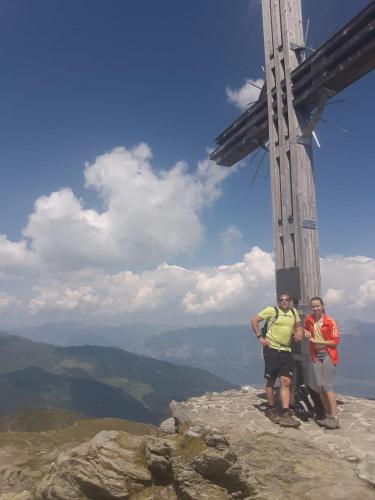 two people standing on top of a mountain with a cross at Gästehaus Schwoagerhof in Fügen