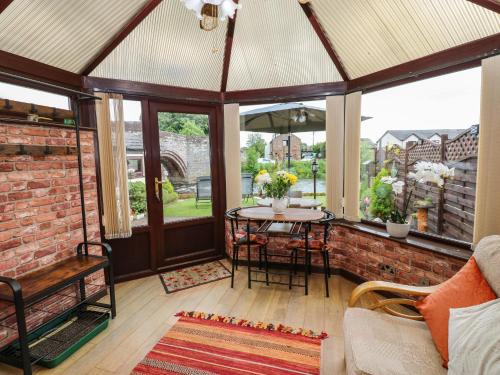 a screened in porch with a table and chairs at River Cottage in Penrith
