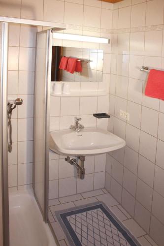 a white bathroom with a sink and a shower at Gästehaus Schwoagerhof in Fügen
