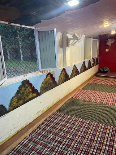 a room with a painting of trees on the wall at Kanva Farms in Kotdwāra