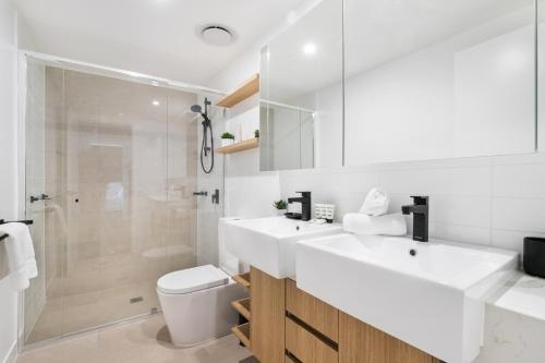 ein Bad mit einem Waschbecken, einem WC und einer Dusche in der Unterkunft Convenient 2-Bed Apartment with Panoramic Views in Brisbane