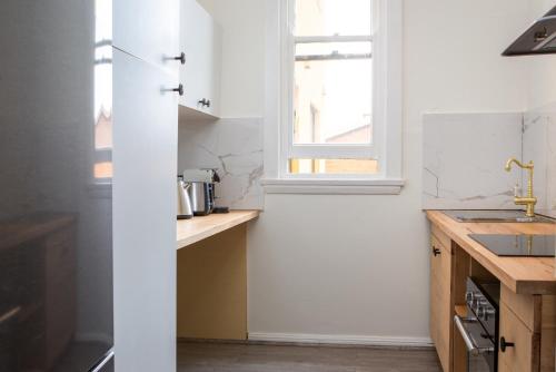 a kitchen with white walls and a window at Central 2-Bed Apartment with Private Parking in Sydney