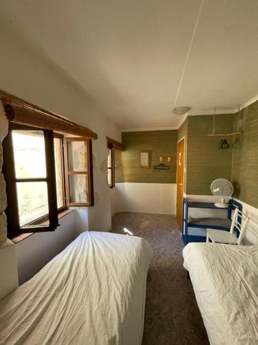 a small room with two beds and a window at Heat Hostel in Susak