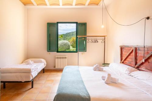 two beds in a room with a window at Mas Tortós in Palafolls
