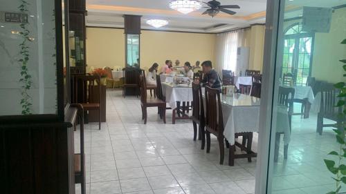 un grupo de personas sentadas en una mesa en un restaurante en CHALEUNXAY HOTEL en Vientián