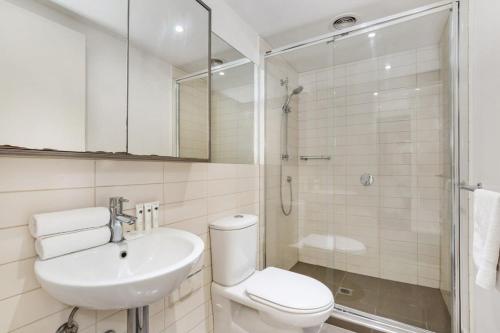 een badkamer met een toilet, een wastafel en een douche bij Chic 2-Bed Oasis in South Melbourne's Heart in Melbourne