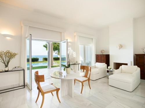 a living room with a table and chairs at Mandola Rosa at Riviera Olympia, A Grecotel Resort to Live in Loutra Killinis